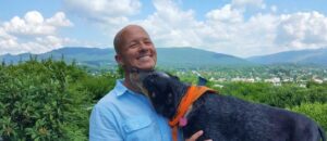 Holistic veterinarian Dr. Matt Parker smiling with his dog outdoors, reflecting his personal approach to holistic veterinary care