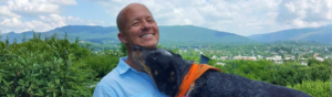 Holistic veterinarian Dr. Matt Parker smiling with his dog outdoors, reflecting his personal approach to holistic veterinary care